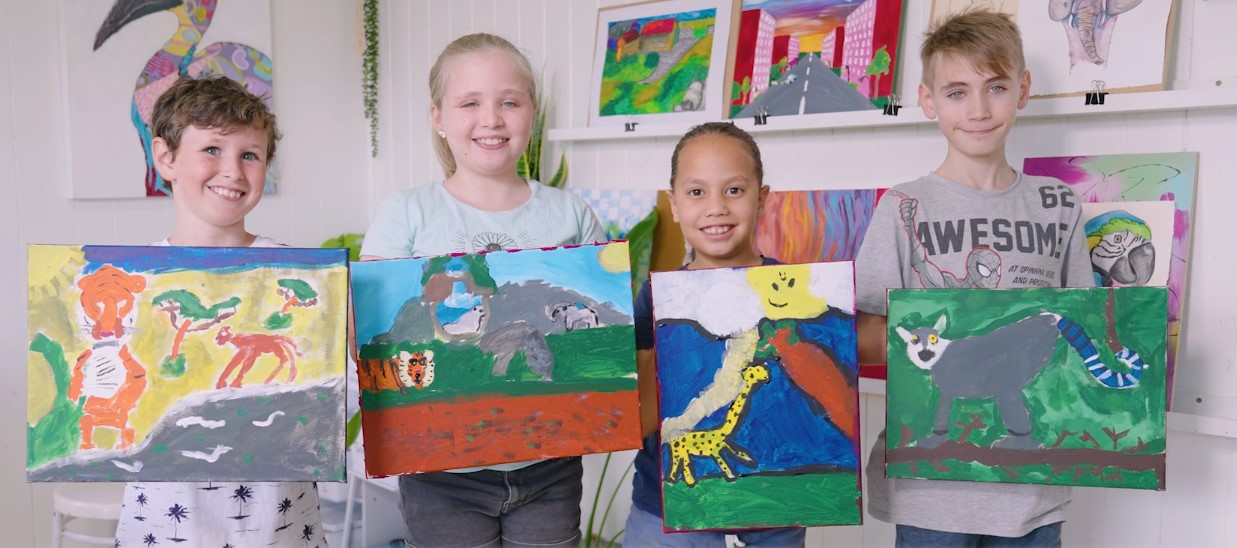 Liam and his friends showing their paintings.