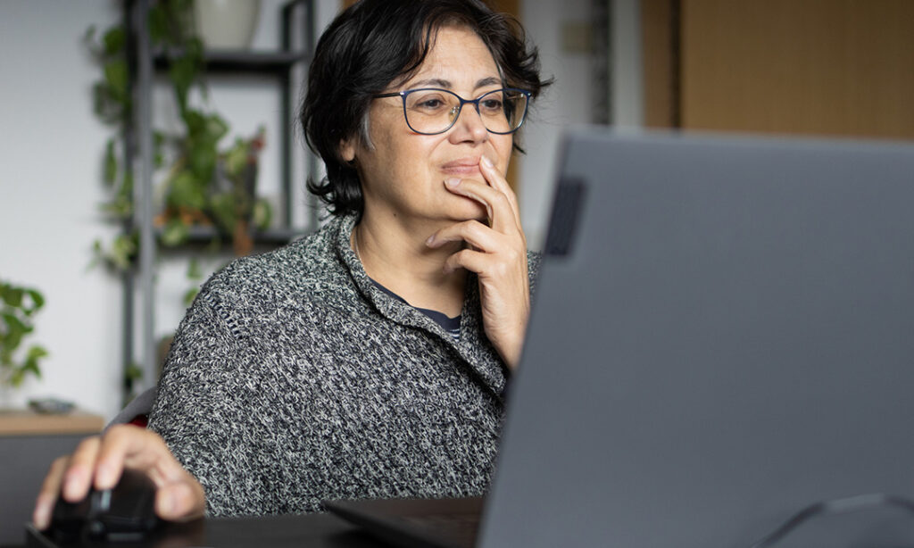 Mature woman of Middle Eastern ethnicity entrepreneur working on her small online business from a laptop in her home office. she is happy and smiling because she is a successful professional.