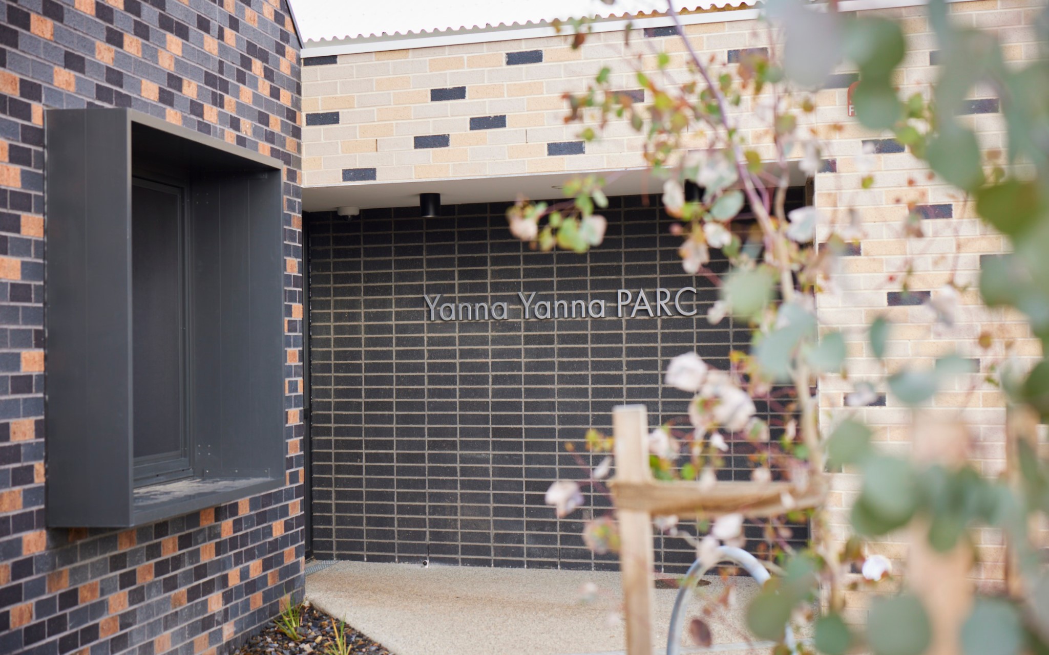 The front of a brick and tile building with the words Yanna Yanna PARC on the wall.