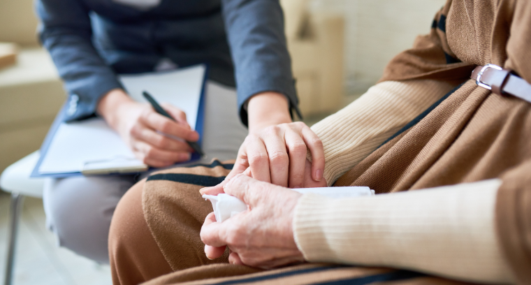 A support worker holds someones hand