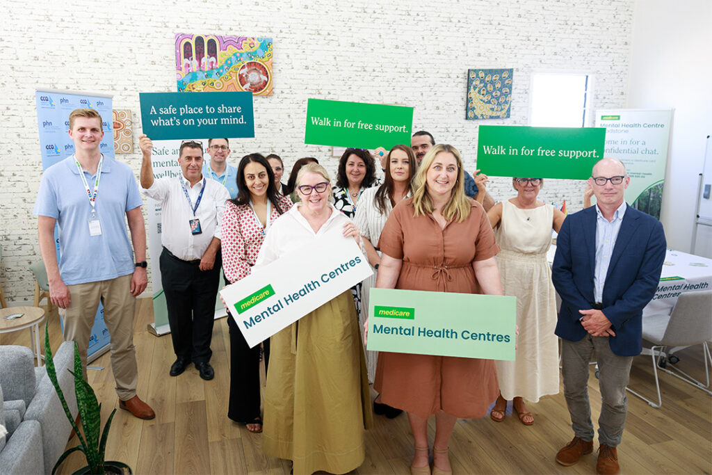 The Wellways and Medicare Mental Health Centre representatives along with The Hon Emma McBride MP and Dr Matthew Warden holding signs for the launch of the Rockhampton Medicare Mental health Centre.