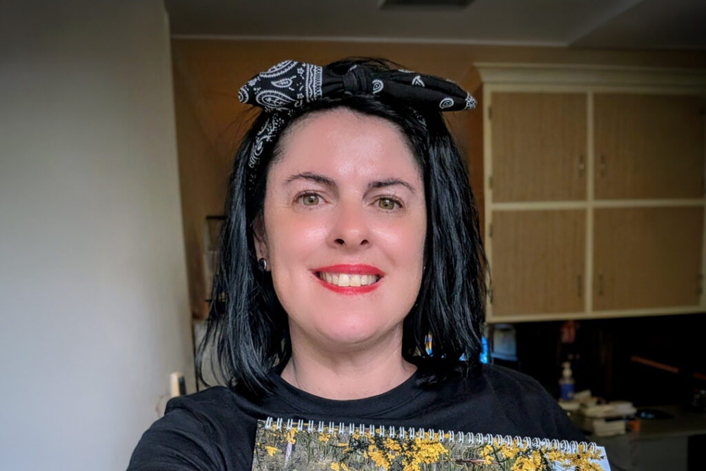 A person with dark hair wearing a hairbow and red lipstick