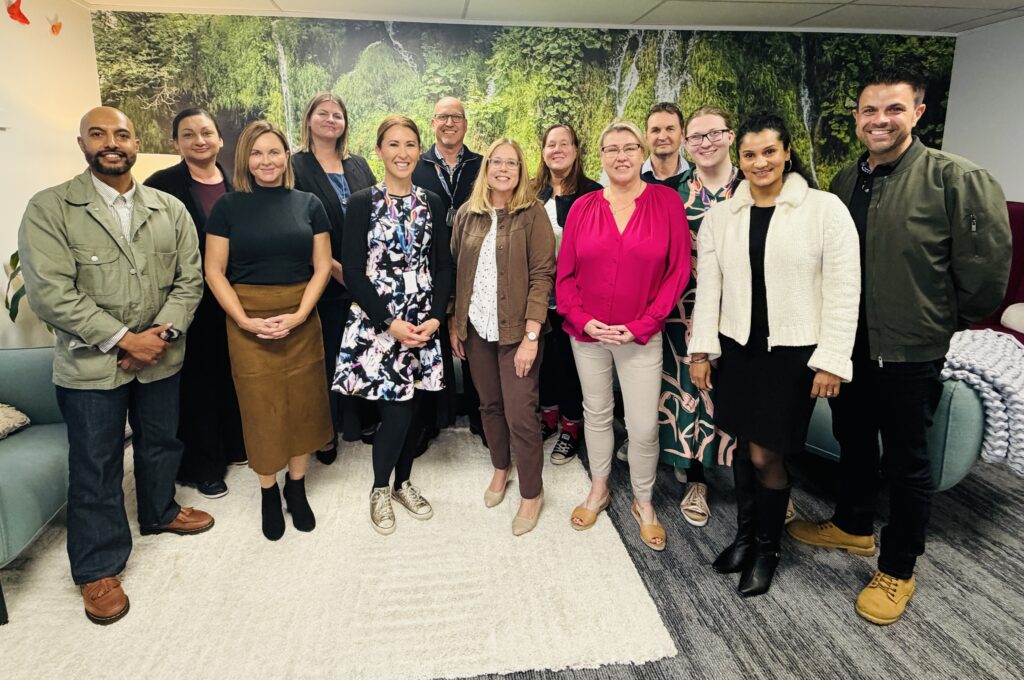 A group of people in an office grouped together for a photo