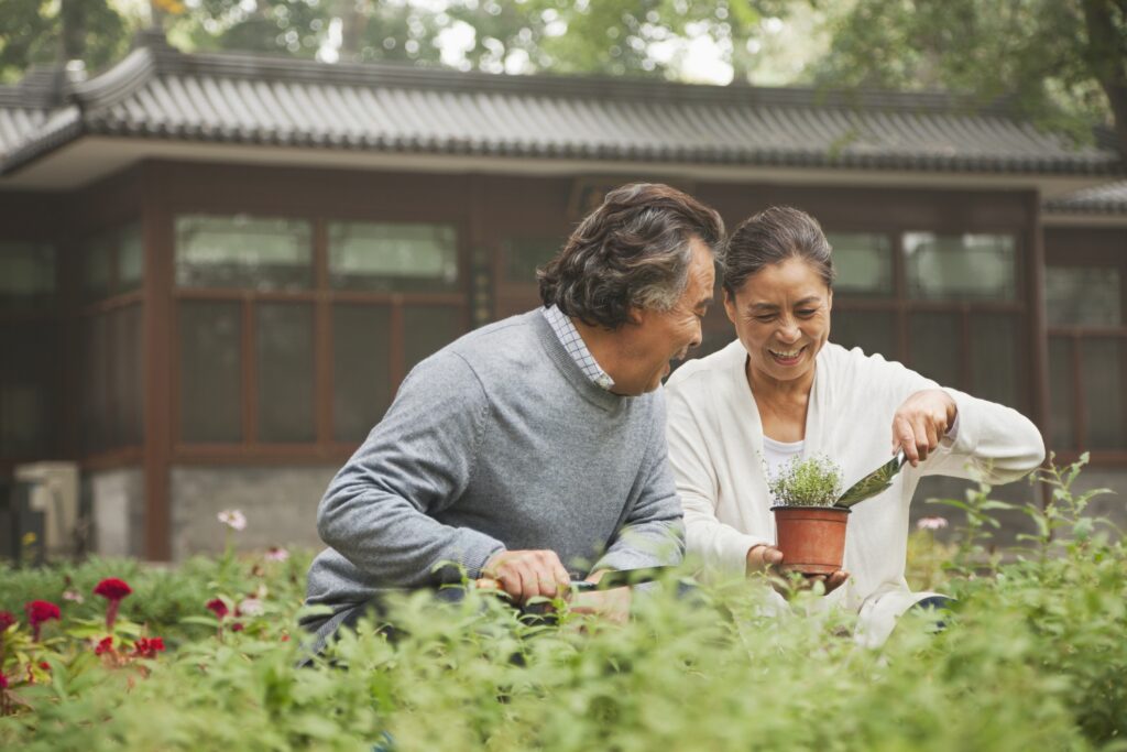 A couple gardening together in front of a japanese style house
