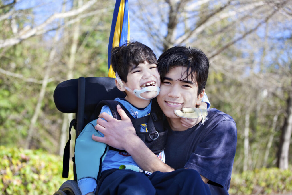 Father embracing his son with a disabiltiy.