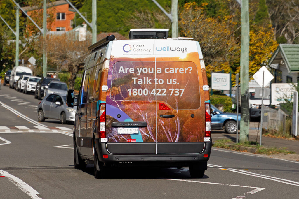 A colourful van driving down an urban street