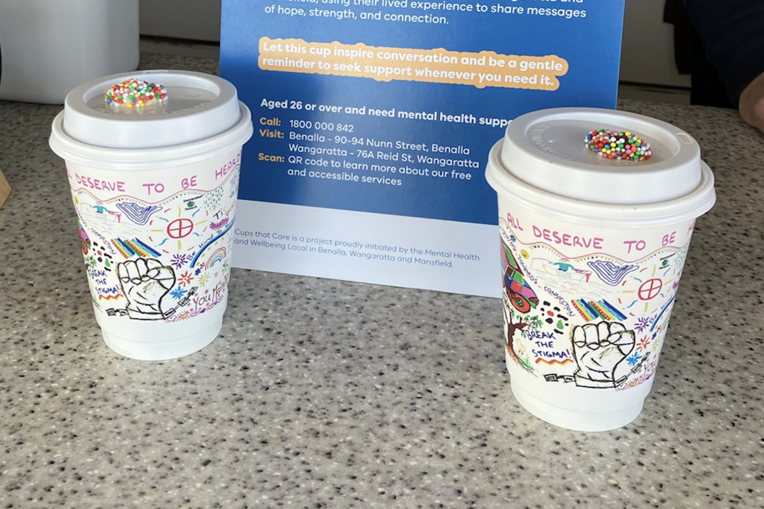 Coffee cups with printed artwork on a marble bench