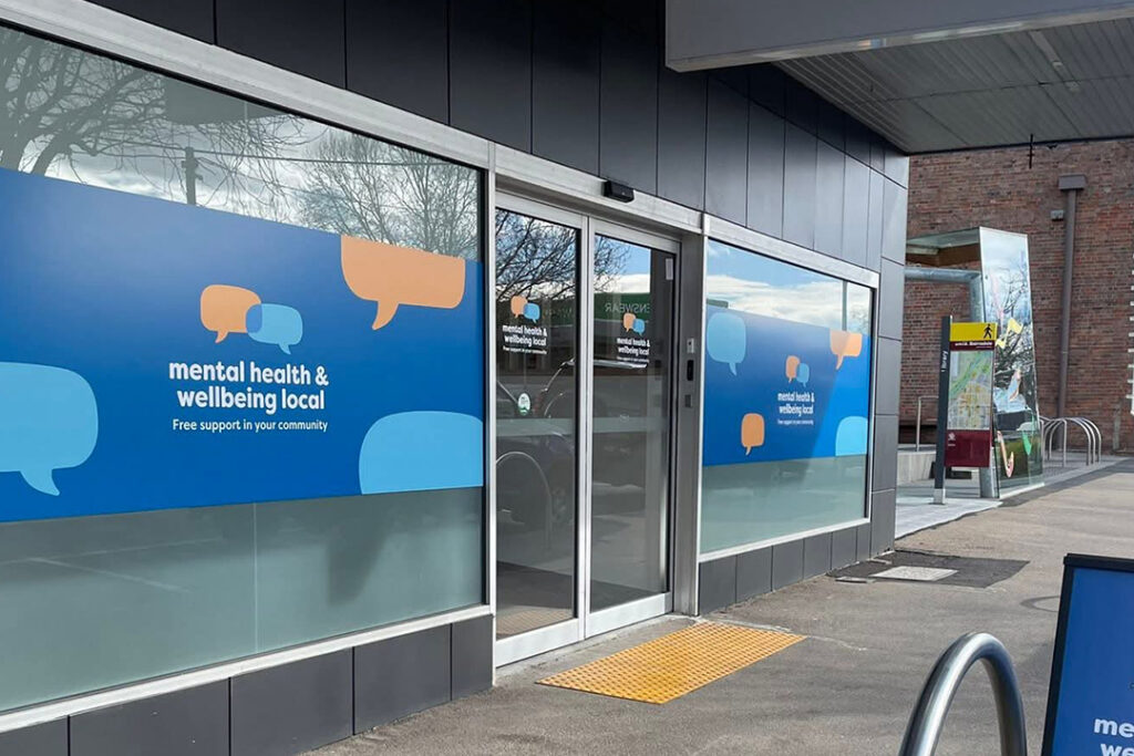 Front door to a building with blue and orange signage.