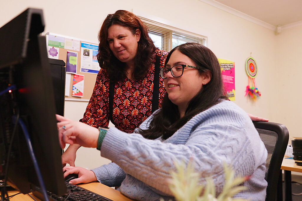 A person watching over another person using a computer