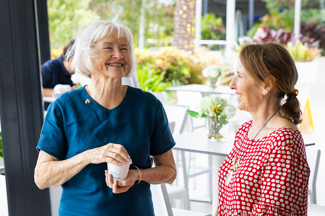 Two people chatting and laughing at an outdoor cafe