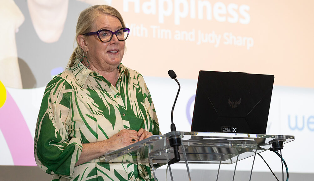 A person standing behind a lecturn speaking