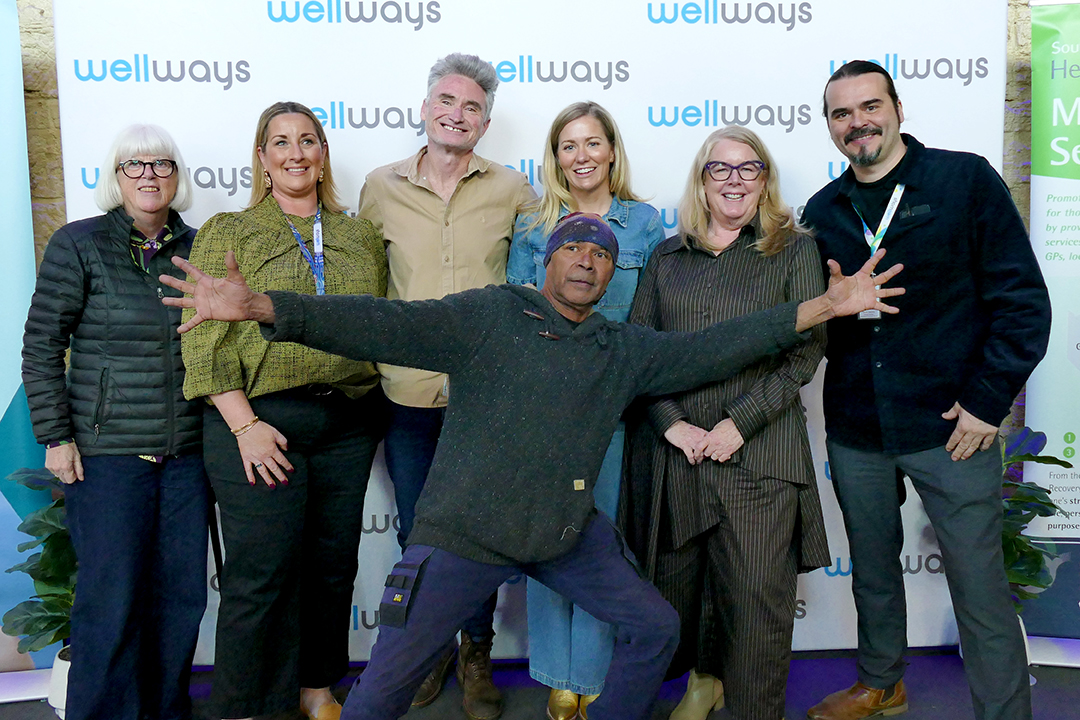 A group of people in front of a branded media wall.