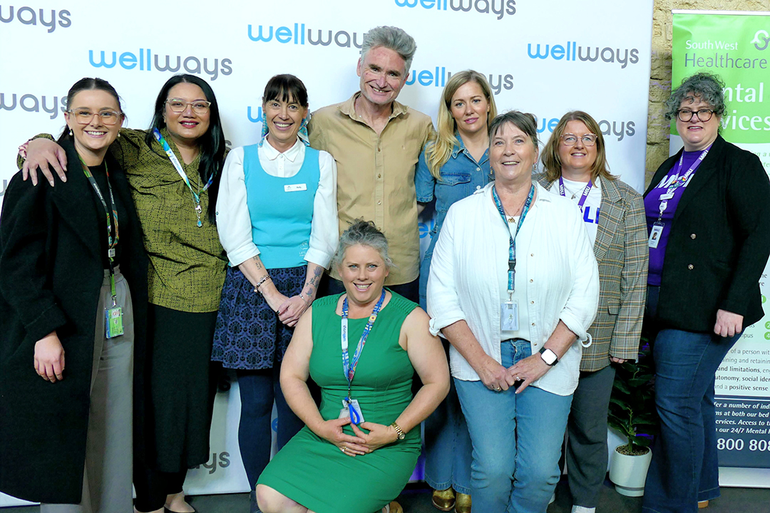 A group of people in front of a branded media wall.