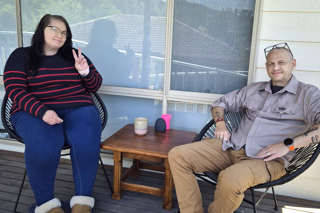 Two people sitting in deck chairs on a balcony