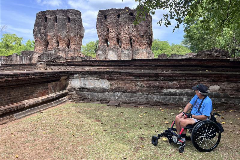 A person in a wheelchair looking at ancient ruins outdoors