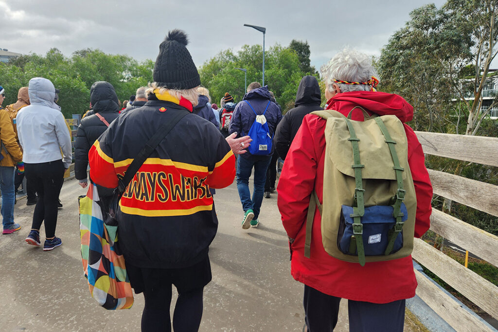 A group of people walking on a bridge.
