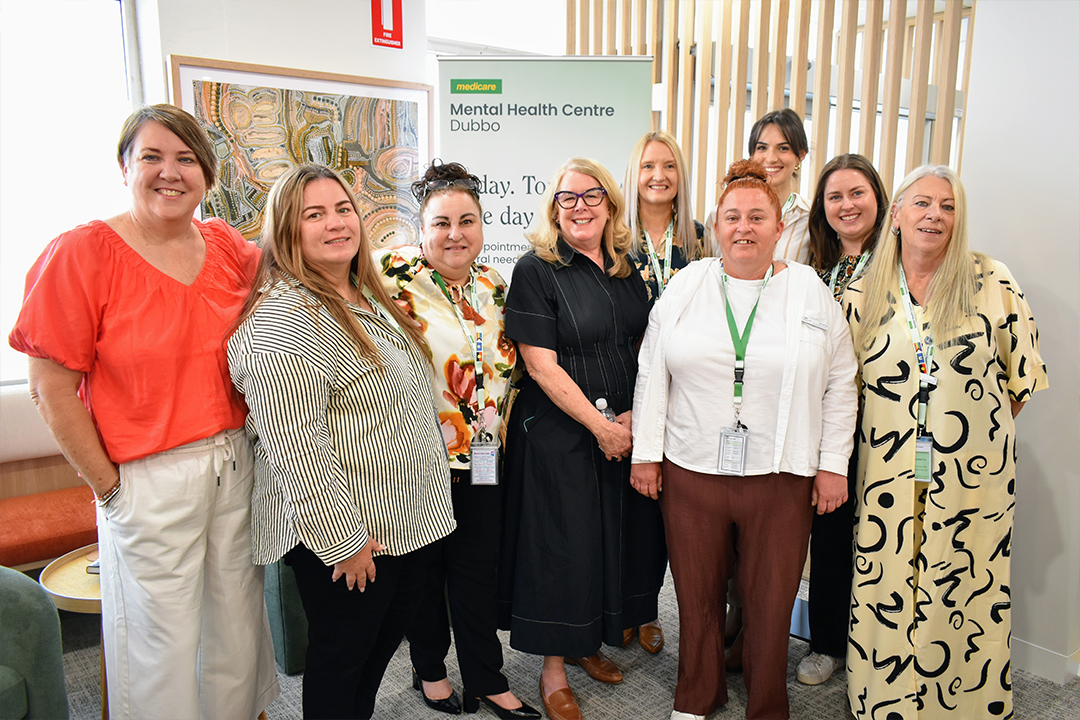 A group of people in a well lit room posing for a photo. 