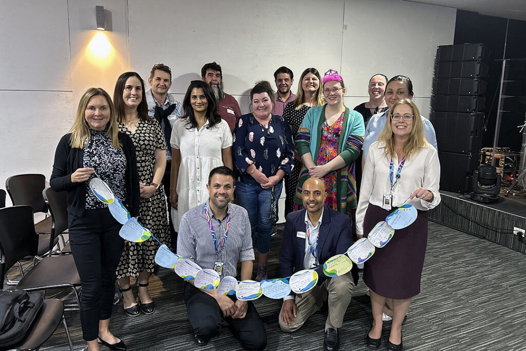A group of people in an office grouped together for a photo