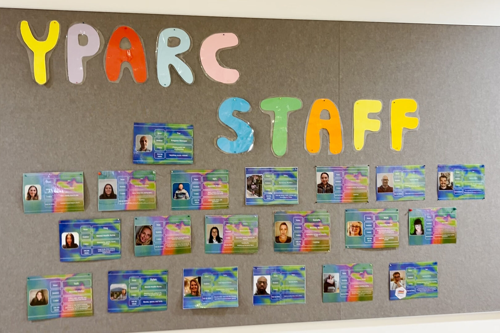 A wall with the words YPARC STAFF and a collection of photos