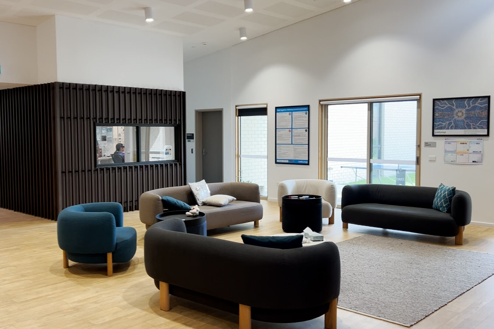 A wide open room with natural light and dark furniture