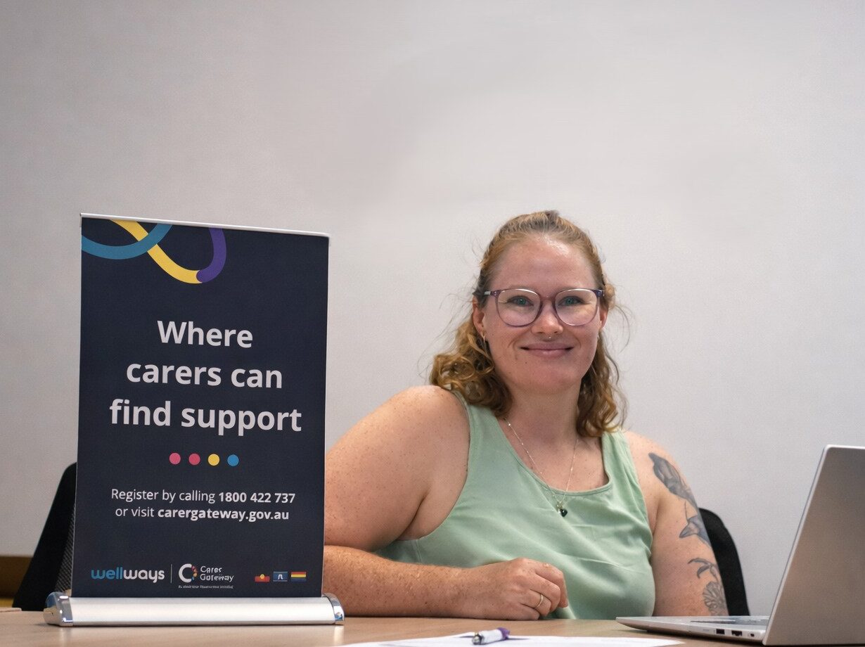 Young woman in an office with a laptop and banner