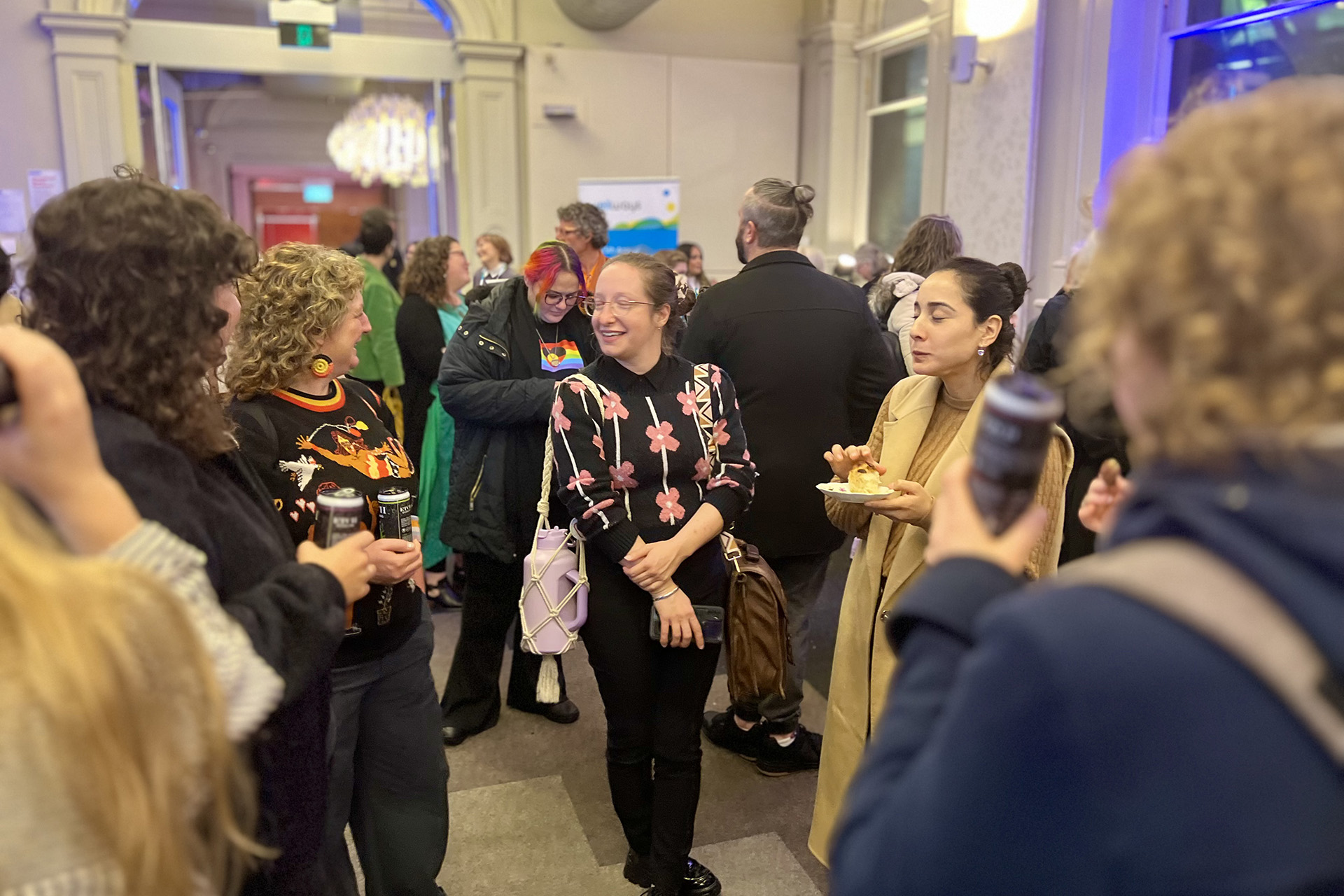 A room full of people chatting and laughing at an event.