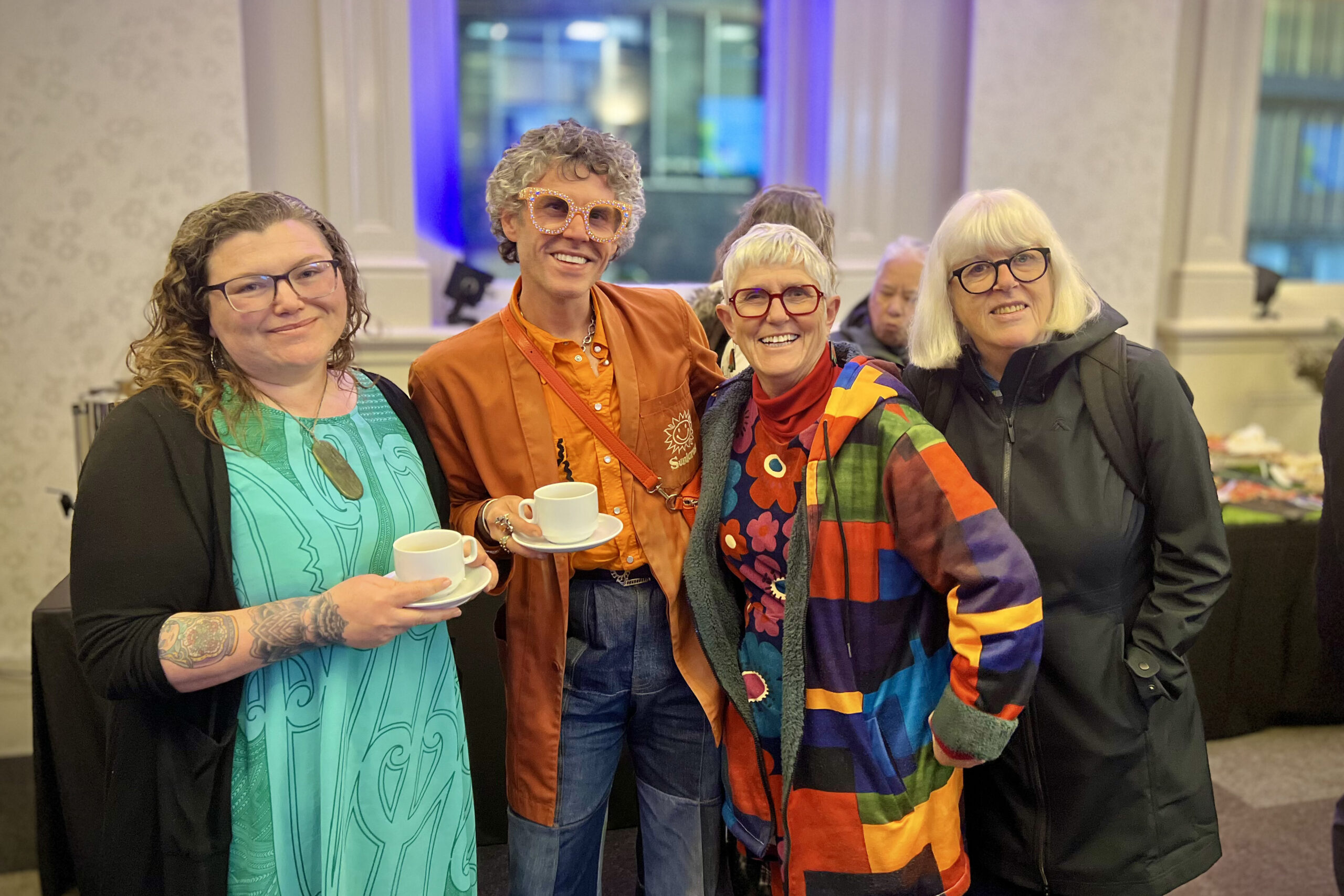 Four people posing for a photo at an event.