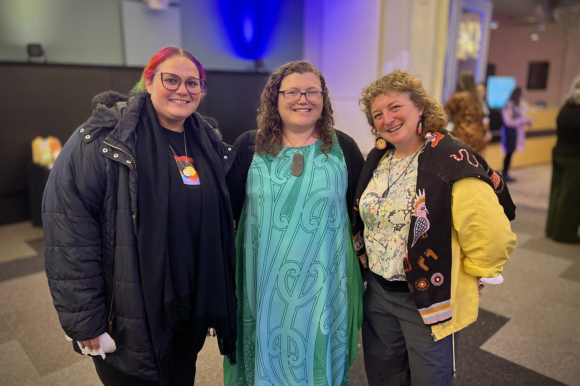 Three people posing for a photo at an event.
