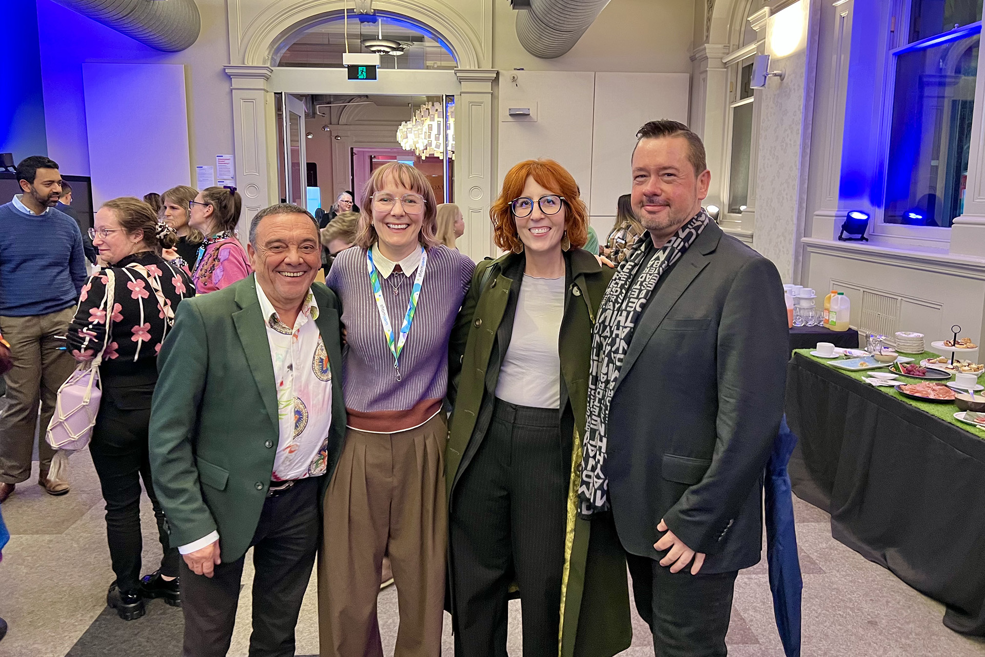 Four people posing for a photo at an event.