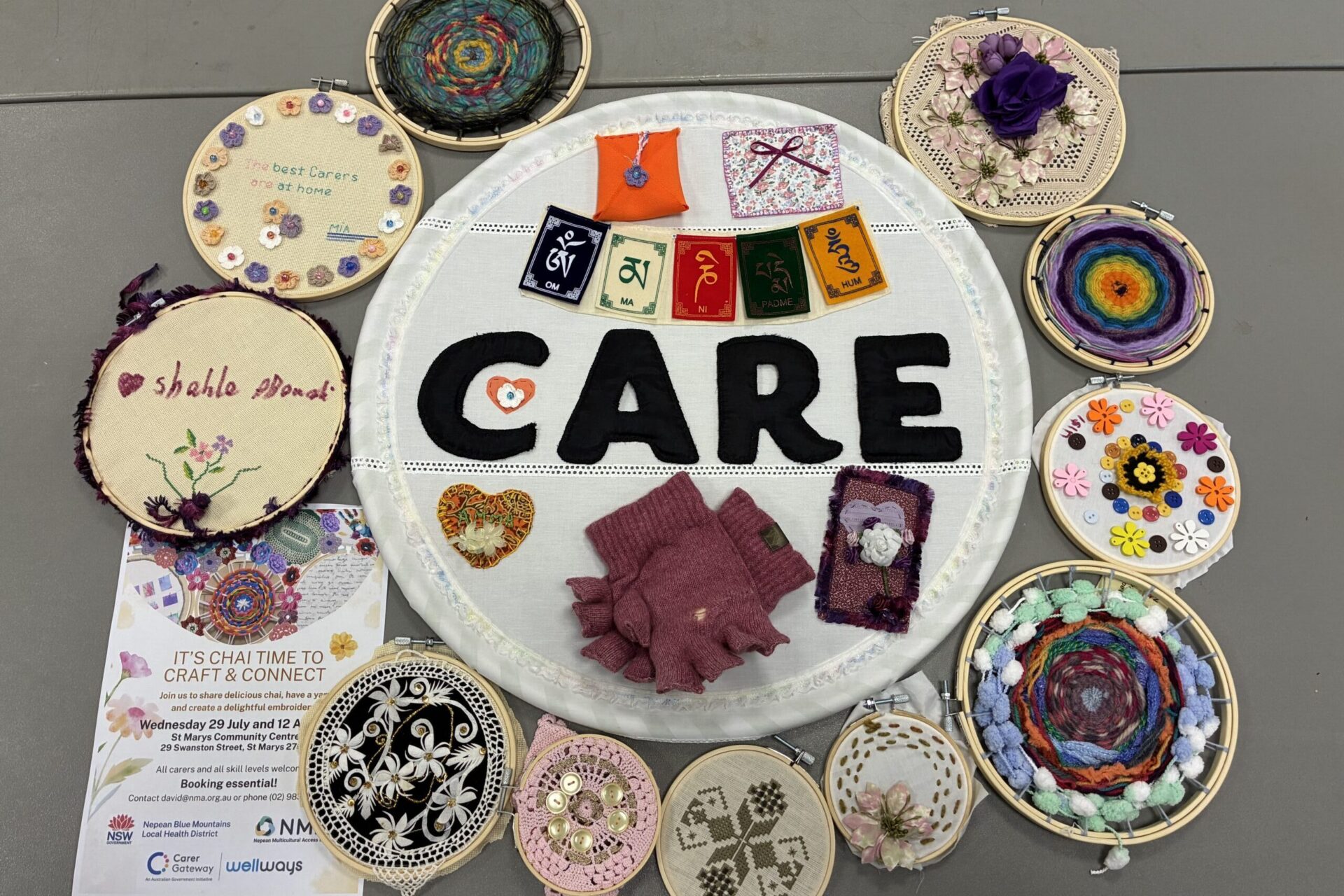 A big embroidery hoop with the word Care in the middle surrounded by smaller decorated embroidery hoops