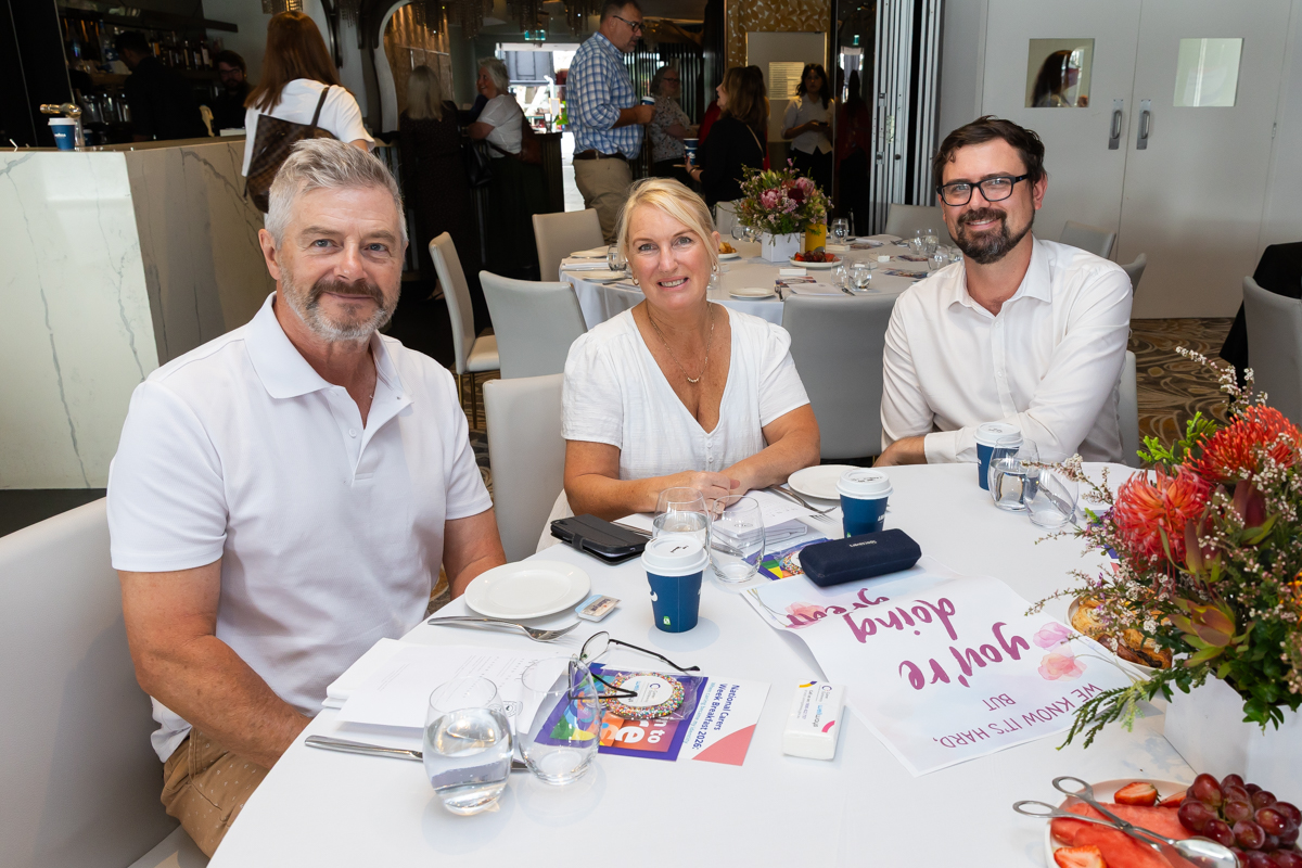 Three people sitting down at a table